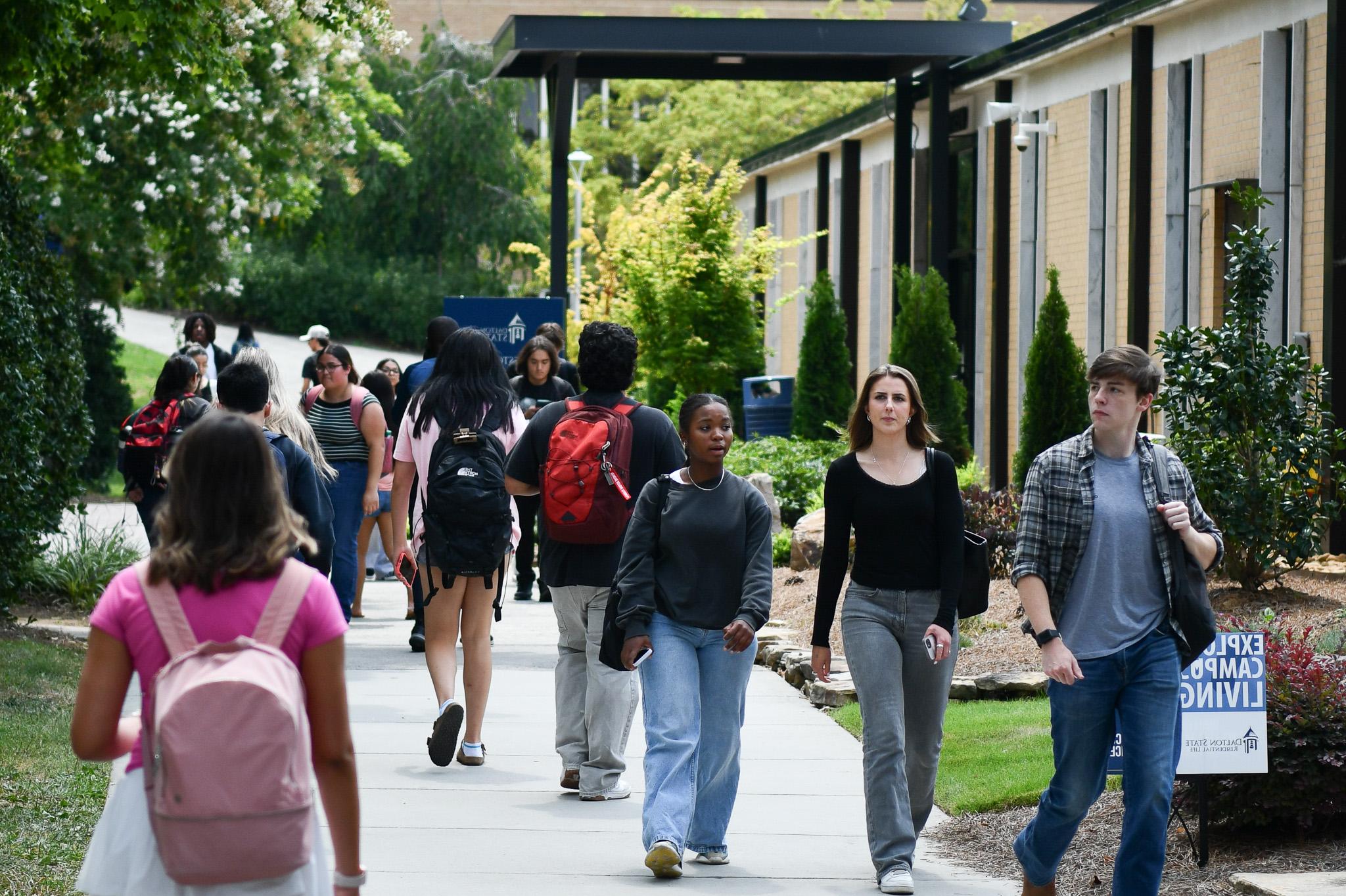 Students walking to and from classrooms on campus walkway